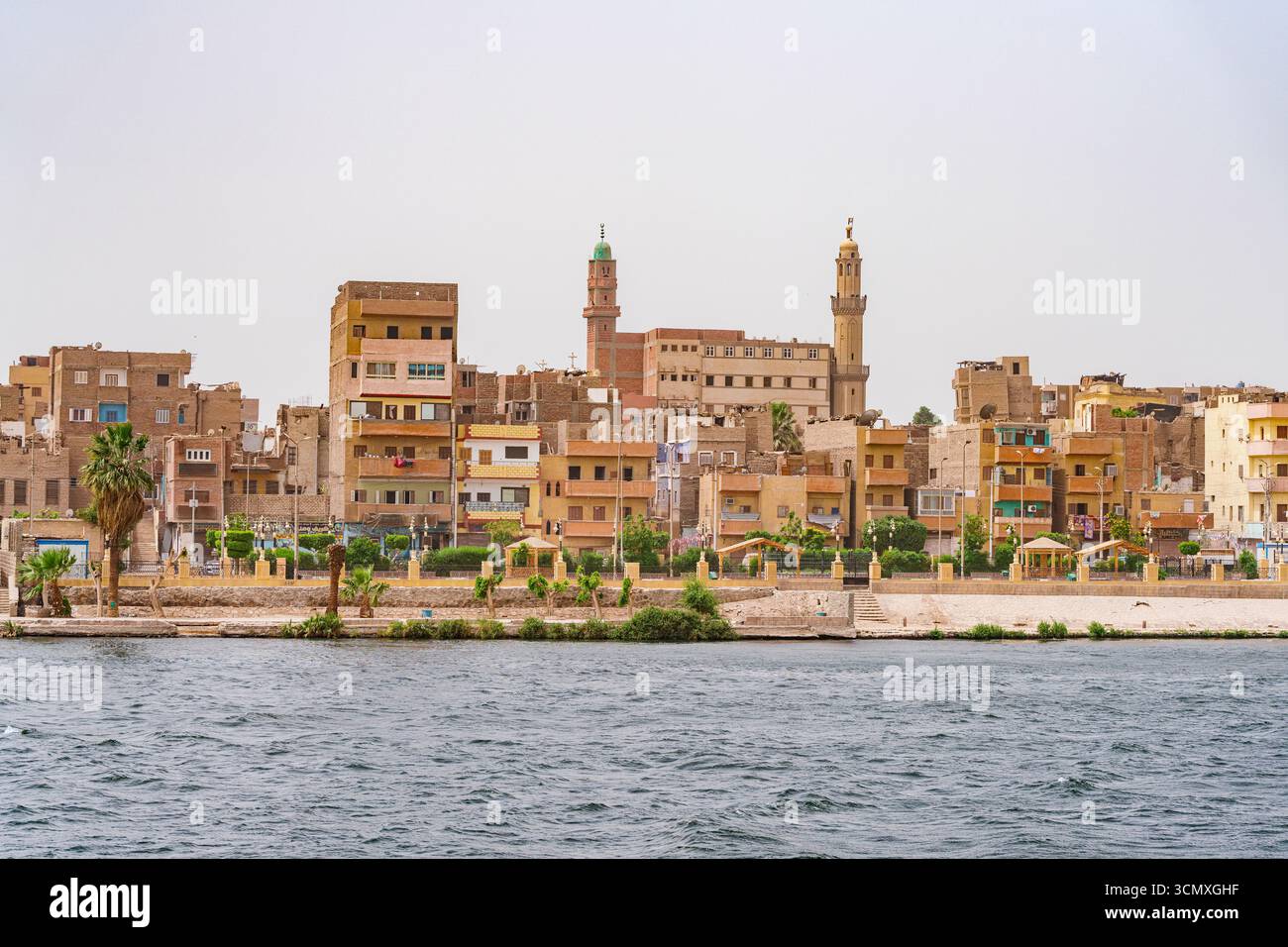 Città egiziana e moschea lungo le rive del Nilo, Egitto Foto Stock