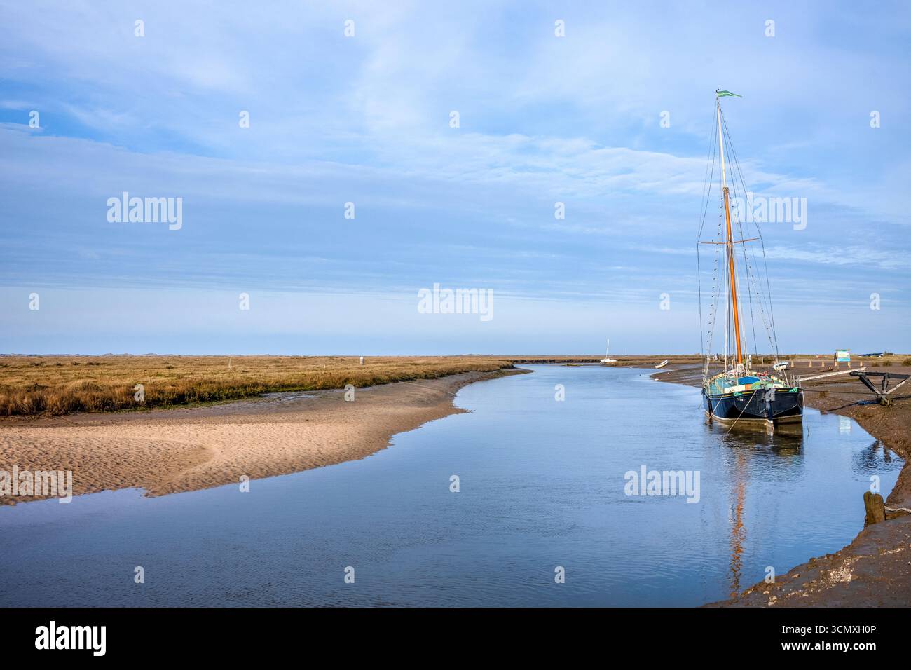 Yacht ormeggiato sulle rive del fiume Glaven, con paludi oltre, a Blakeney nel North Norfolk, Regno Unito Foto Stock