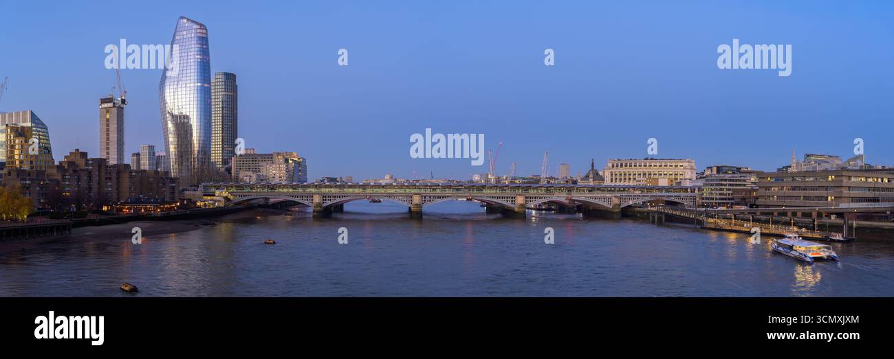 Una splendida alba proietta colori caldi sul fiume Tamigi, illuminando gli edifici iconici di Londra. Foto Stock