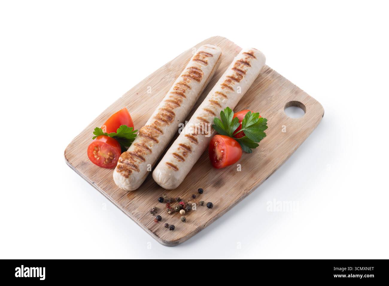 Salsicce Bratwurst grigliate con pomodori ciliegini e prezzemolo isolati su sfondo bianco Foto Stock