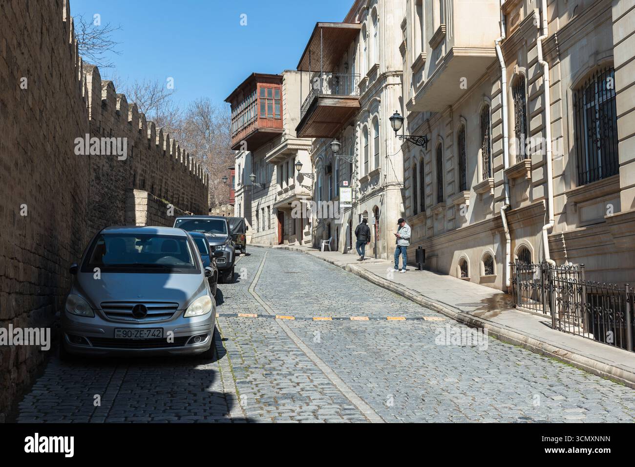 Baku, Azerbaigian - 25 marzo 2025: Vista sulla via Kichik Qala. Una tranquilla strada urbana caratterizzata da architettura storica, auto parcheggiate e una calda atmosfera Foto Stock