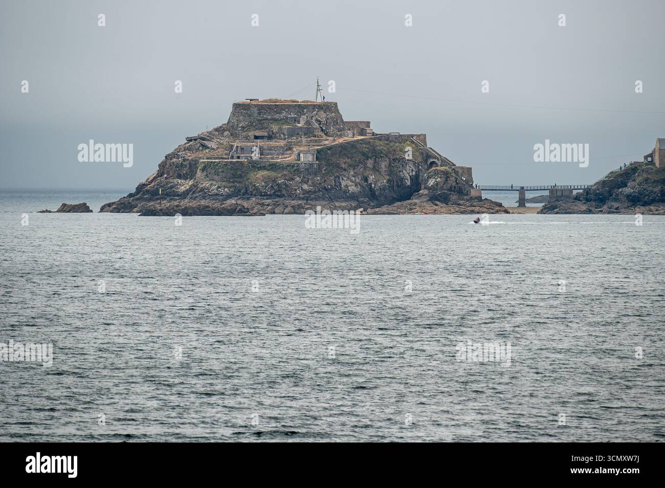 Fort de Bertheaume sorge su un'isola di marea al largo della costa della Bretagna, in Francia, con le sue fortificazioni in pietra che contrastano con il cielo grigio coperto e l'ATL Foto Stock
