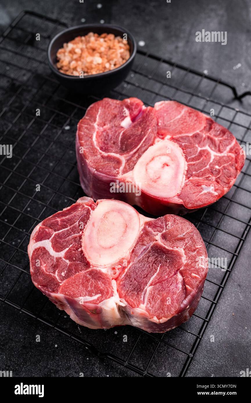Ossobuco crudo fresco codolo di vitello Premium, ideale per cucinare lentamente e creare pasti sostanziosi e confortanti che impressionano. sfondo nero. vista dall'alto. Foto Stock