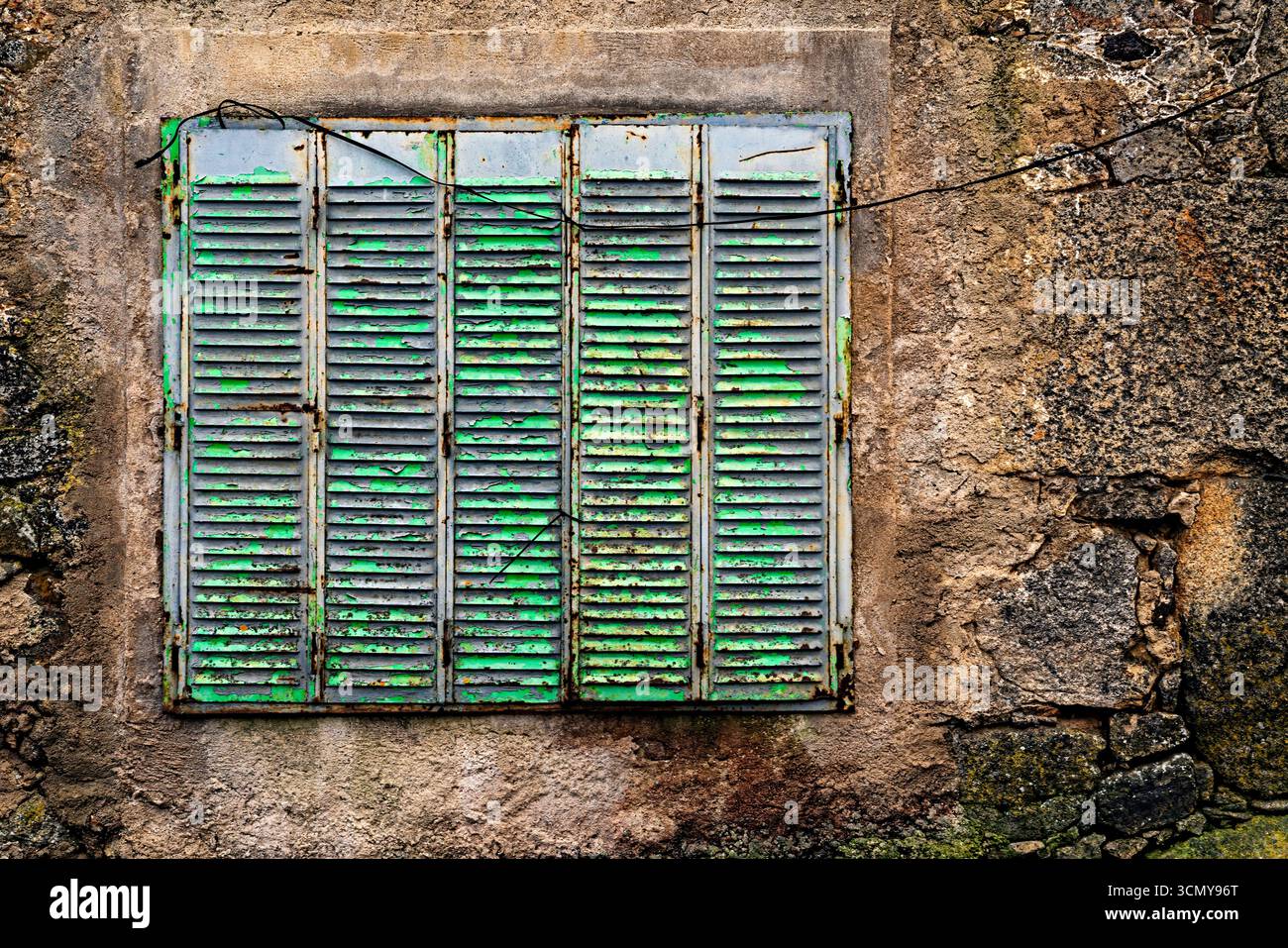 Finestra in un muro di pietra. L'architettura rurale in Spagna abbandonata e semi-demolita a causa della migrazione verso le città. Foto Stock