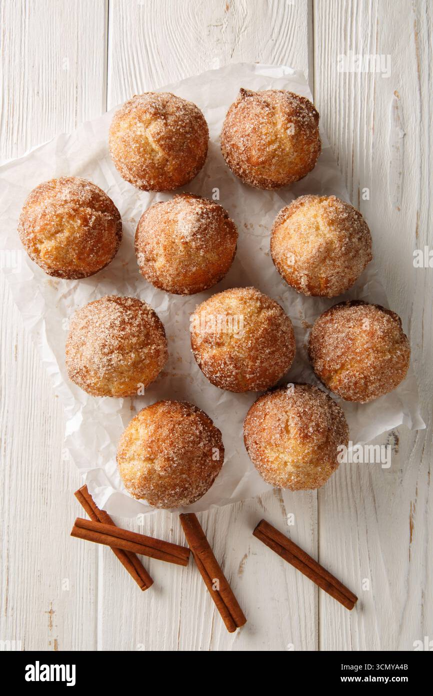 Muffin alla cannella e zucchero e ciambelle i cupcake ricoperti di zucchero sono cotti al forno e non fritti da vicino sul tavolo di legno. Vista dall'alto verticale Foto Stock