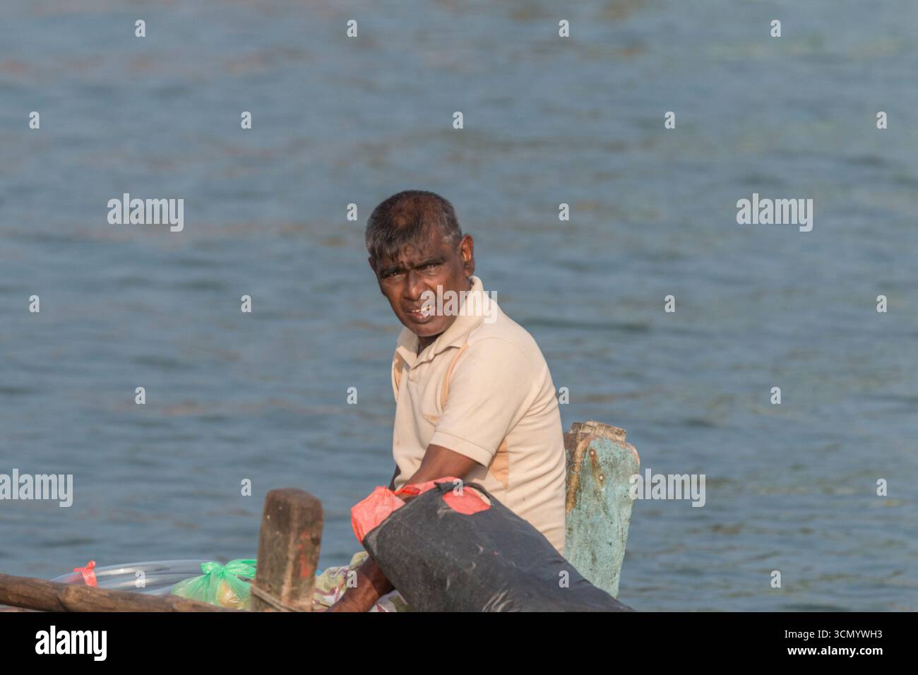 Sri Lanka - Mirissa - Porto - pescatore seduto sul molo con uno sguardo lontano Foto Stock