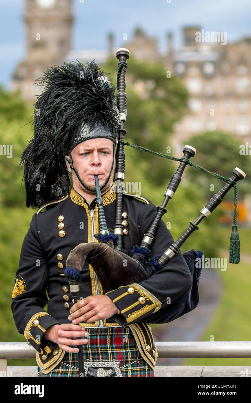 Scozia - Edimburgo - Bagpiper - musicista tradizionale scozzese in uniforme completa Foto Stock