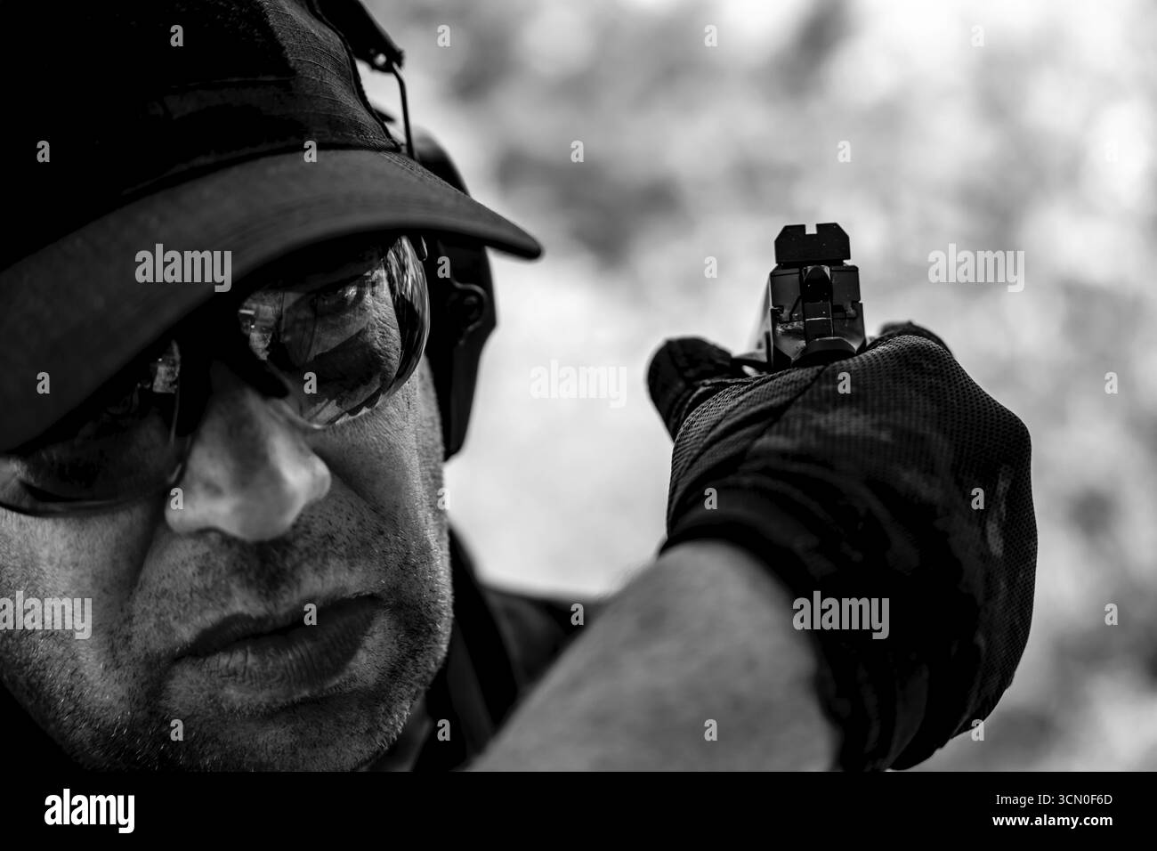 Uomo con cappello e occhiali protettivi con una pistola all'indietro in Svizzera Foto Stock
