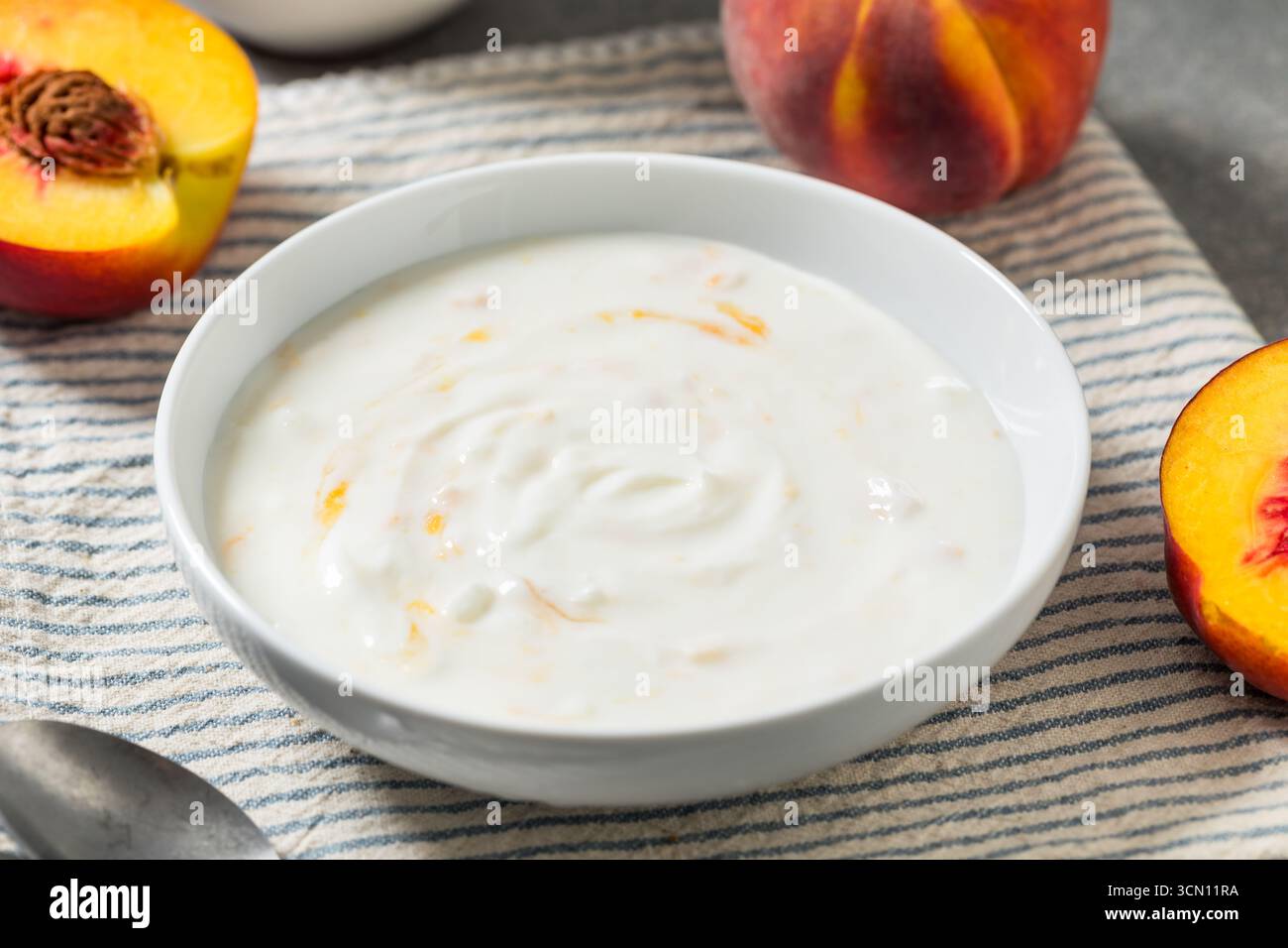 Yogurt di pesca fatto in casa in una ciotola per colazione Foto Stock