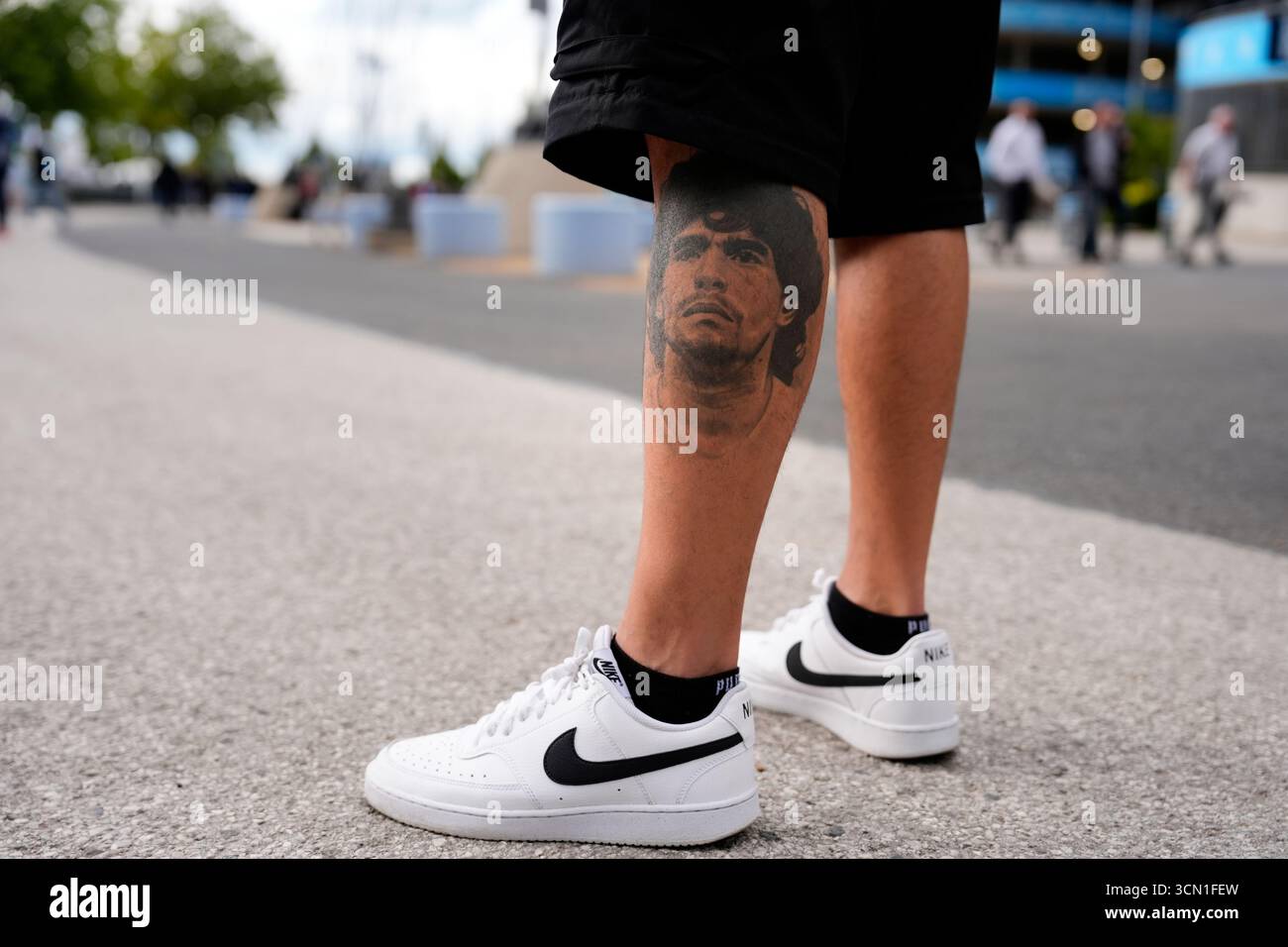 Primo piano di un tifoso del Napoli con un tatuaggio dell'ex giocatore Diego Maradona prima della partita di fase della UEFA Champions League all'Etihad Stadium di Manchester. Data foto: Giovedì 18 settembre 2025. Foto Stock