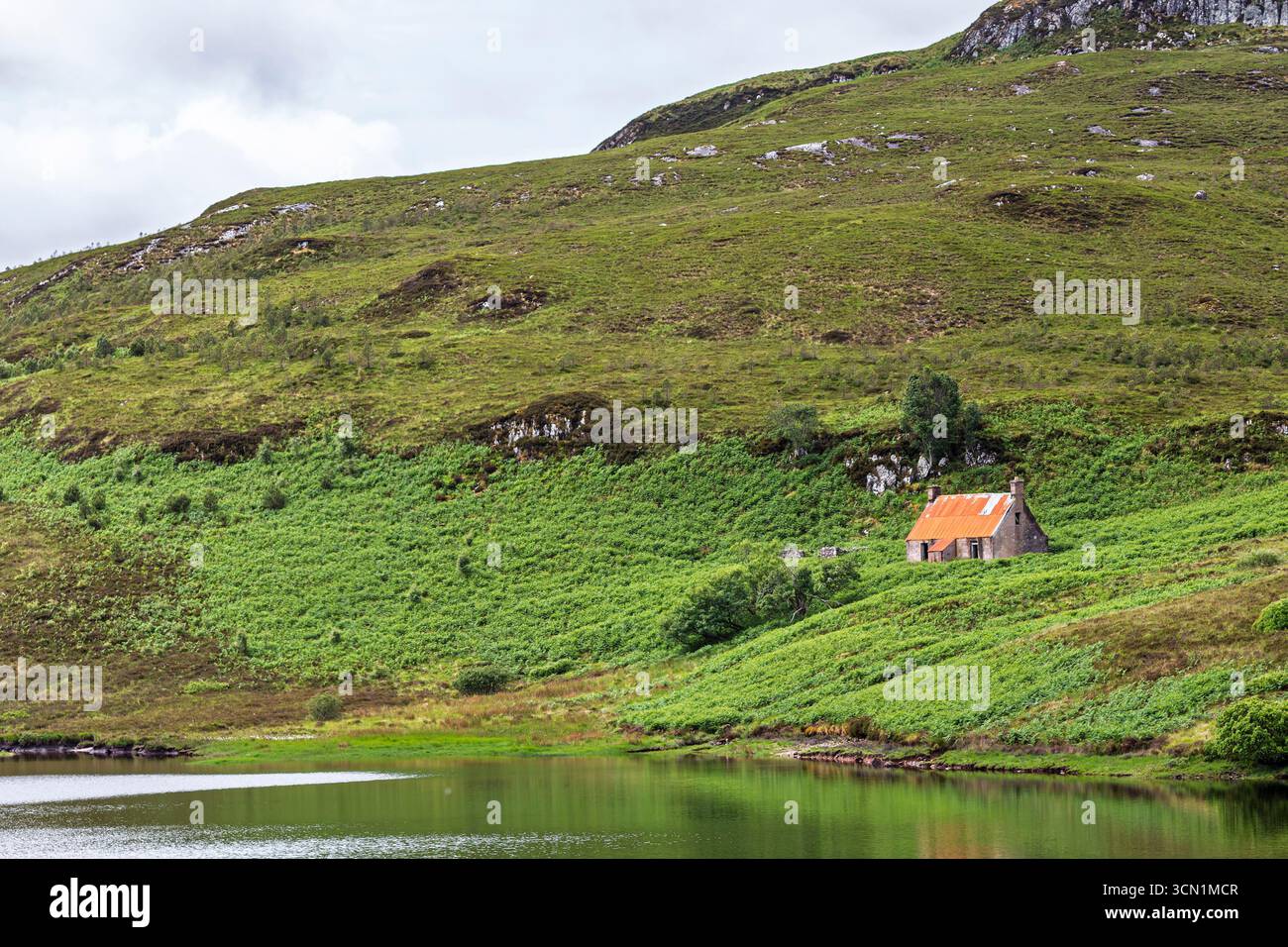 Scozia - Bad An Sgalaig - Loch Bad An Sgalaig - piccolo cottage che si affaccia sul tranquillo loch Foto Stock