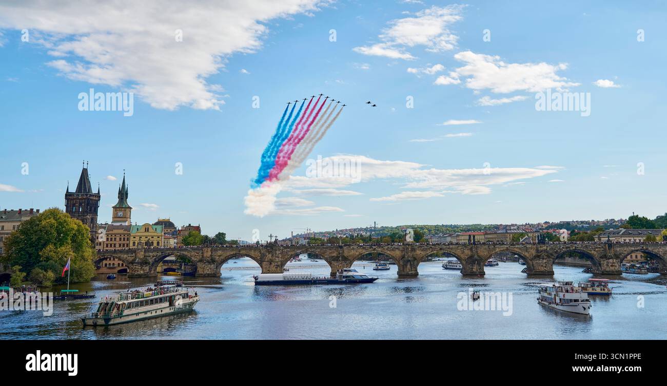 La formazione di due caccia JAS-39 Gripen dell'esercito ceco e di nove aerei britannici BAE Hawk T1 del gruppo Red Arrows della Royal Air Force sorvolano Charles Bridg Foto Stock