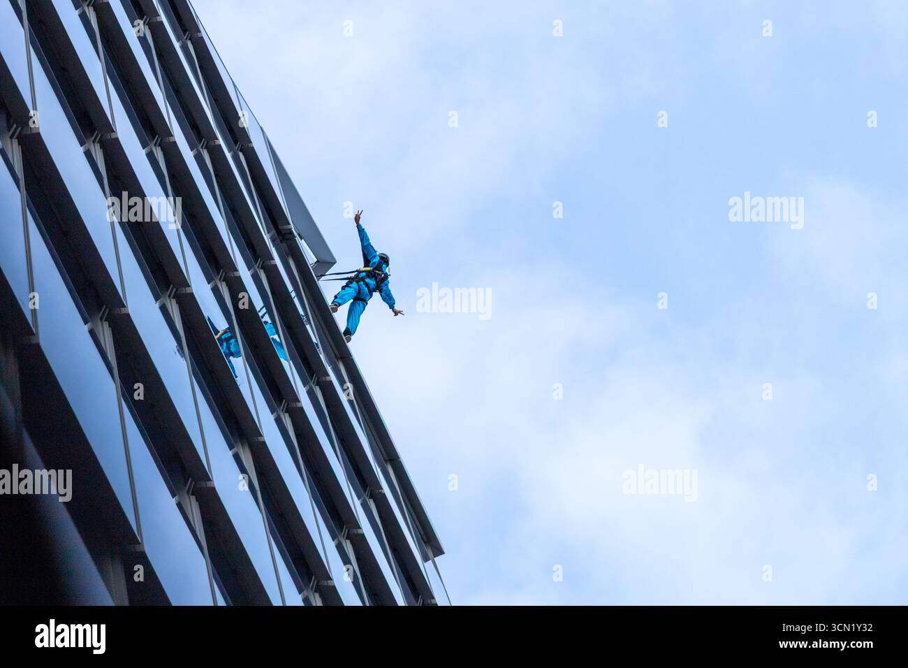 Un uomo in piedi sul bordo di un grattacielo a New York Foto Stock