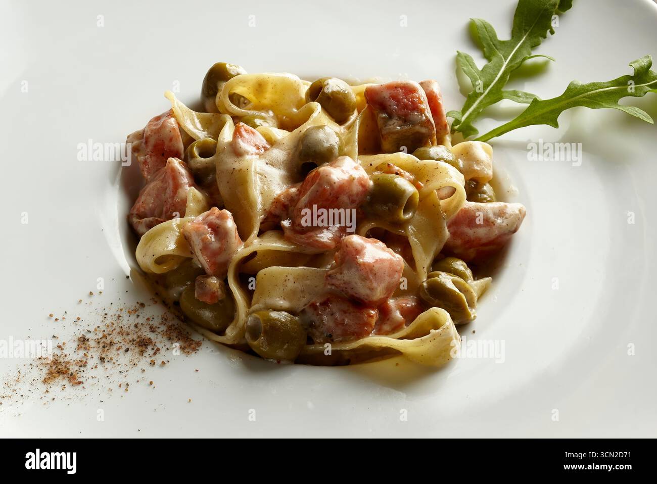 Piatto cremoso di funghi e prosciutto su un piatto bianco guarnito con foglie di rucola. Progettato per il design del menu e la fotografia di scorta con spazio per le copie. Foto Stock