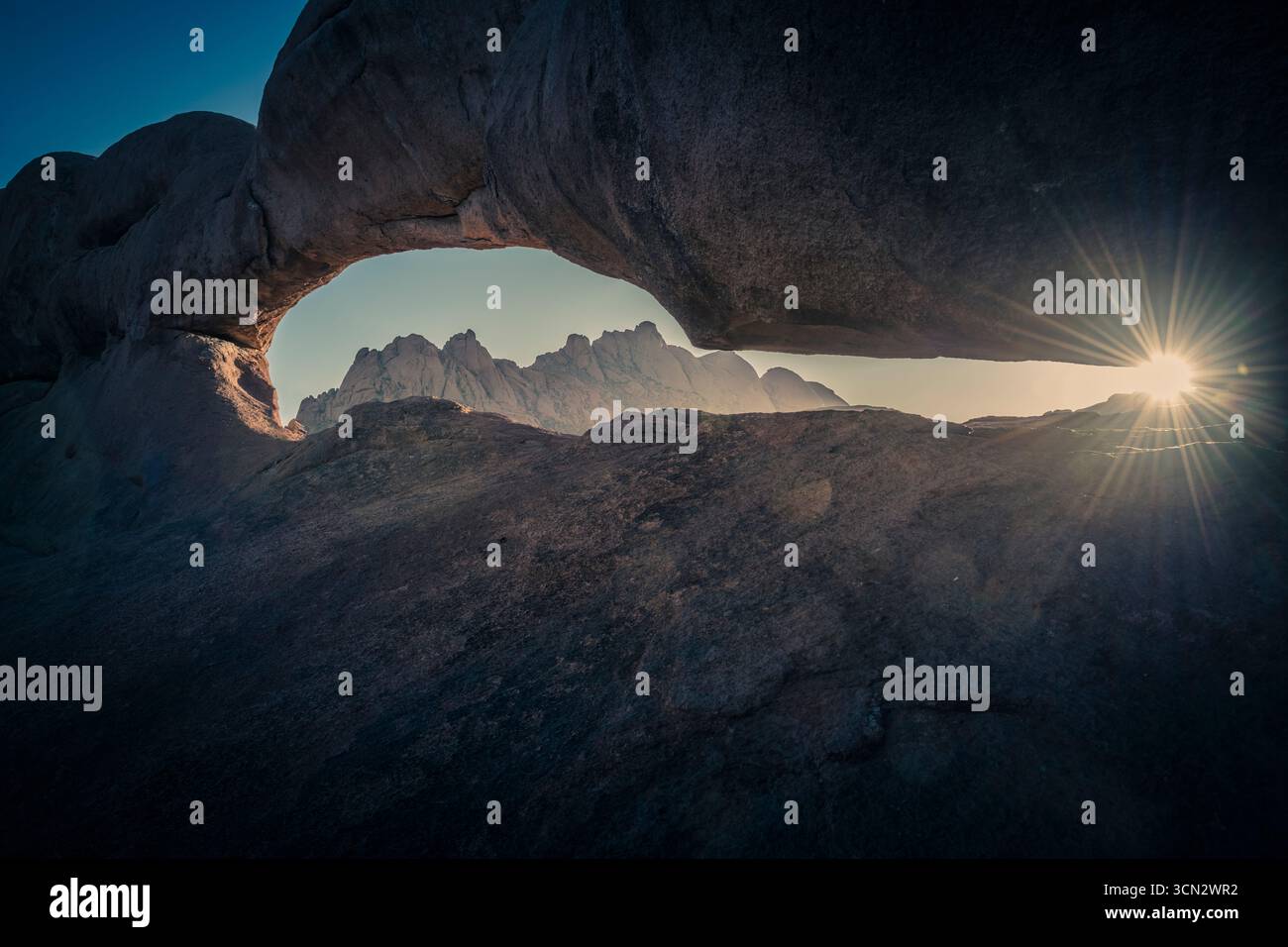 Raggio di luce che passa attraverso l'arco spitzkoppe all'alba Foto Stock