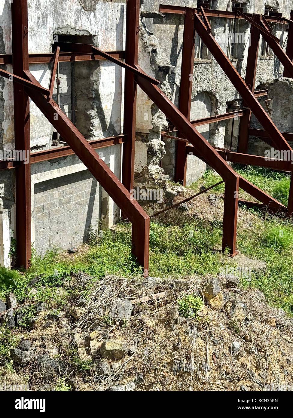 Facciata di un vecchio edificio sostenuta da travi metalliche durante i lavori di restauro in un'area urbana. Foto Stock