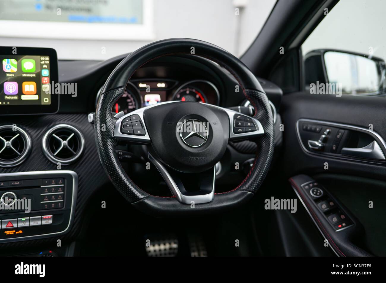 Derby, Regno Unito - 19 settembre 2025: Volante Mercedes-Benz, con l'iconico logo a stella a tre punte, pulsanti multifunzione integrati Foto Stock