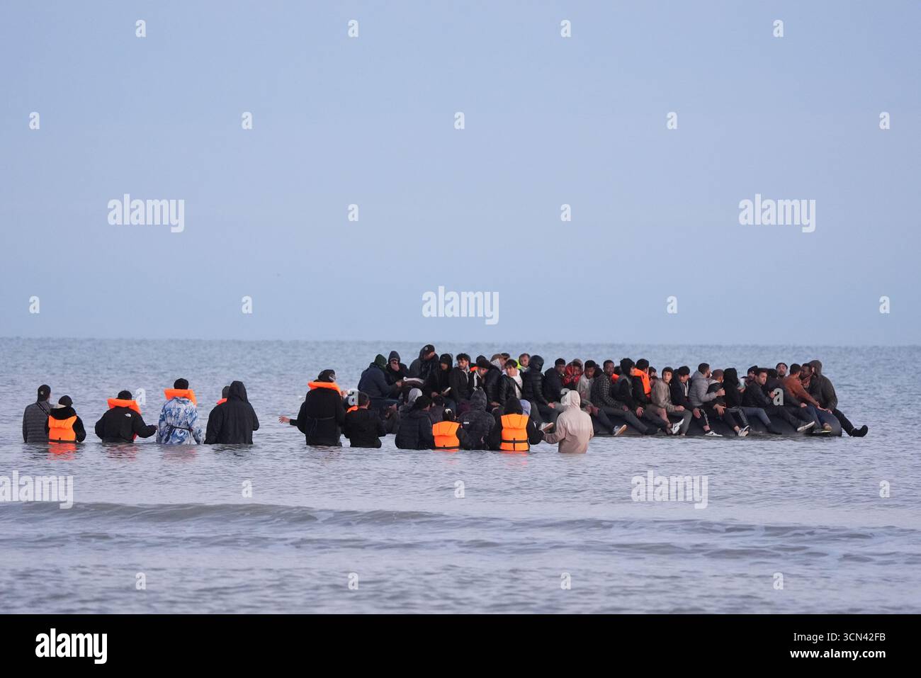 Un gruppo di persone ritenute migranti si tuffò nel mare vicino a Gravelines in Francia per salire su una barca. Data foto: Venerdì 19 settembre 2025. Foto Stock