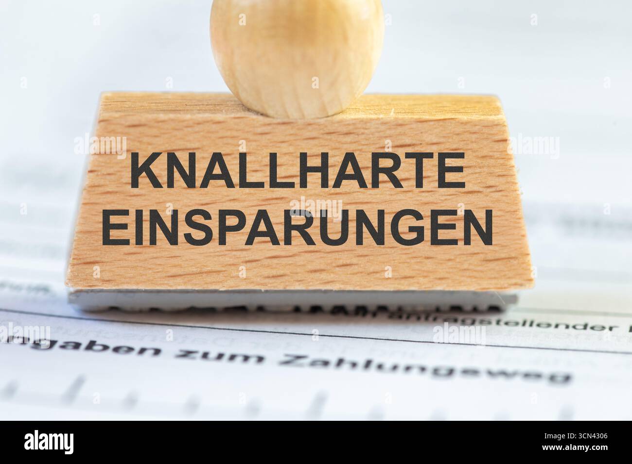 (Montaggio fotografico) primo piano di un francobollo con l'iscrizione KNALLHARTE EINSPARUNGEN Foto Stock