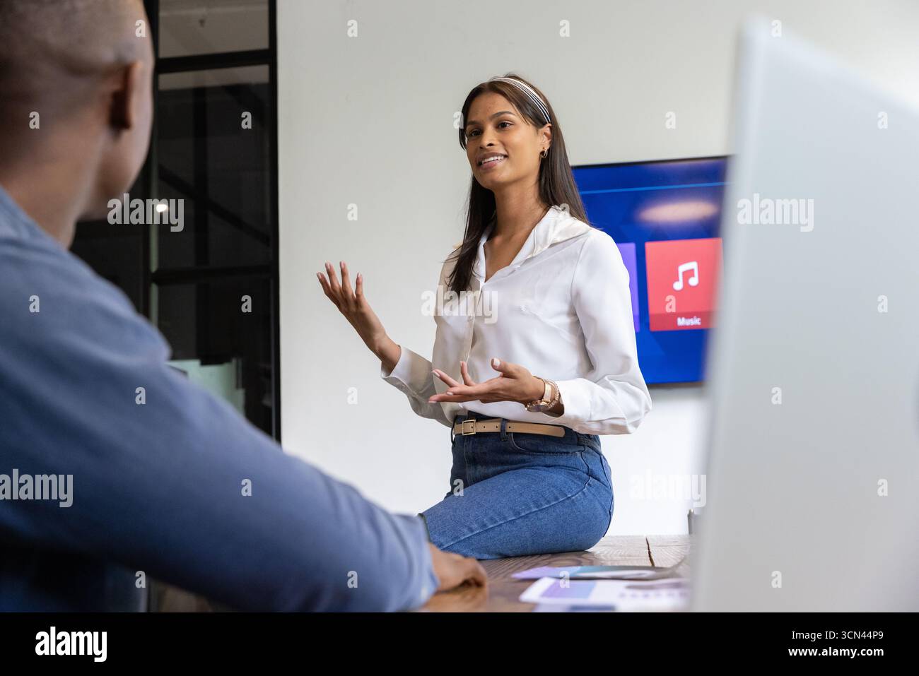 Colleghi diversi seduti al tavolo delle conferenze, discutendo le carte con notebook, tablet, tv Foto Stock