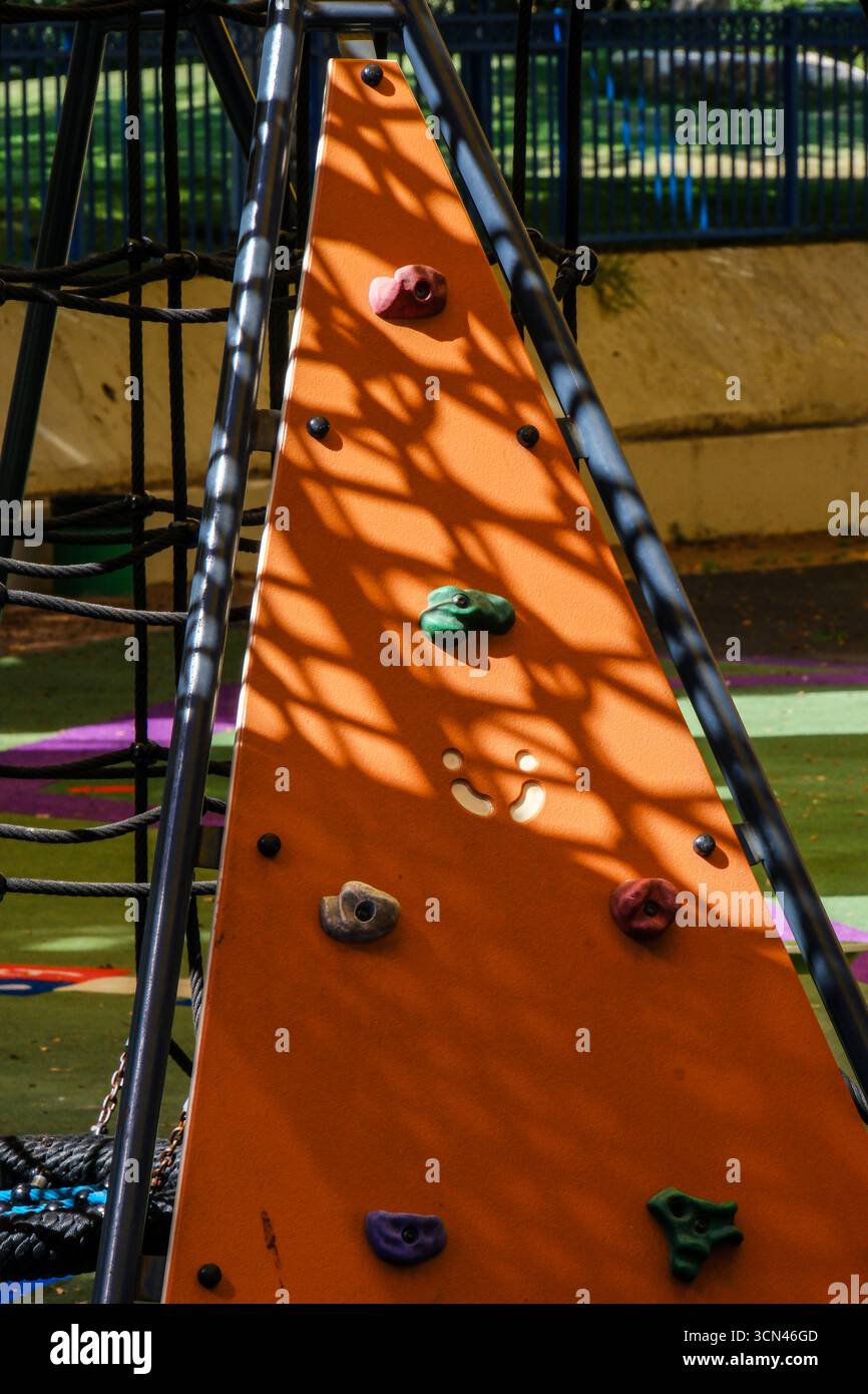 Parete da arrampicata per il parco giochi con trame colorate e motivi d'ombra. Foto Stock