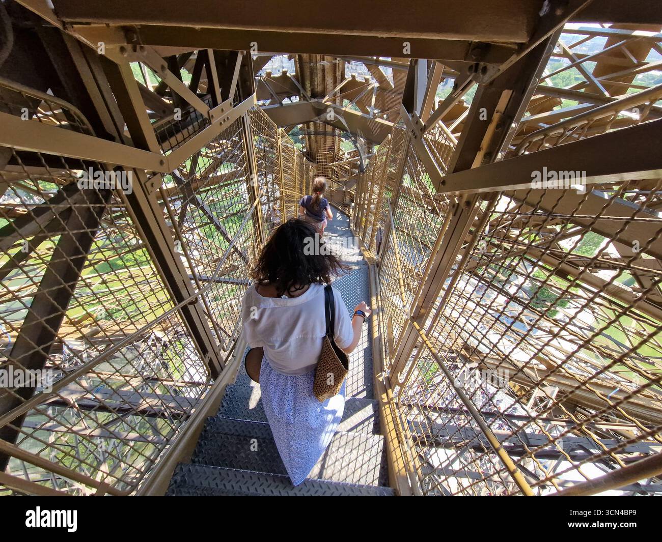 Parigi, Francia - 8 giugno 2023: I turisti camminano su e giù per le scale della Torre Eiffel in una giornata di sole. Foto Stock