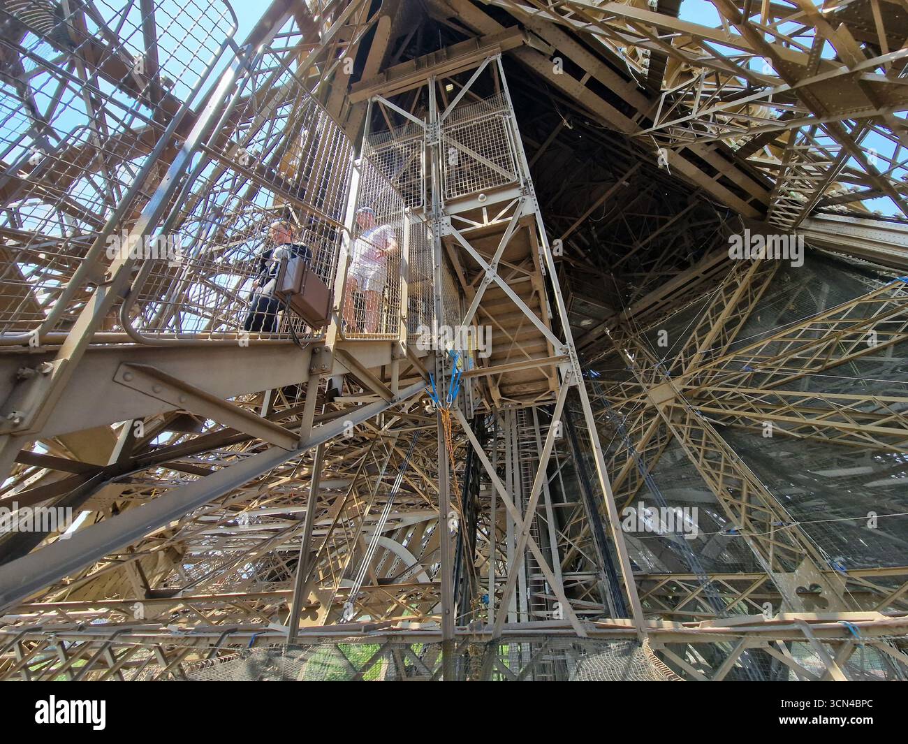Parigi, Francia - 8 giugno 2023: I turisti camminano su e giù per le scale della Torre Eiffel in una giornata di sole. Foto Stock