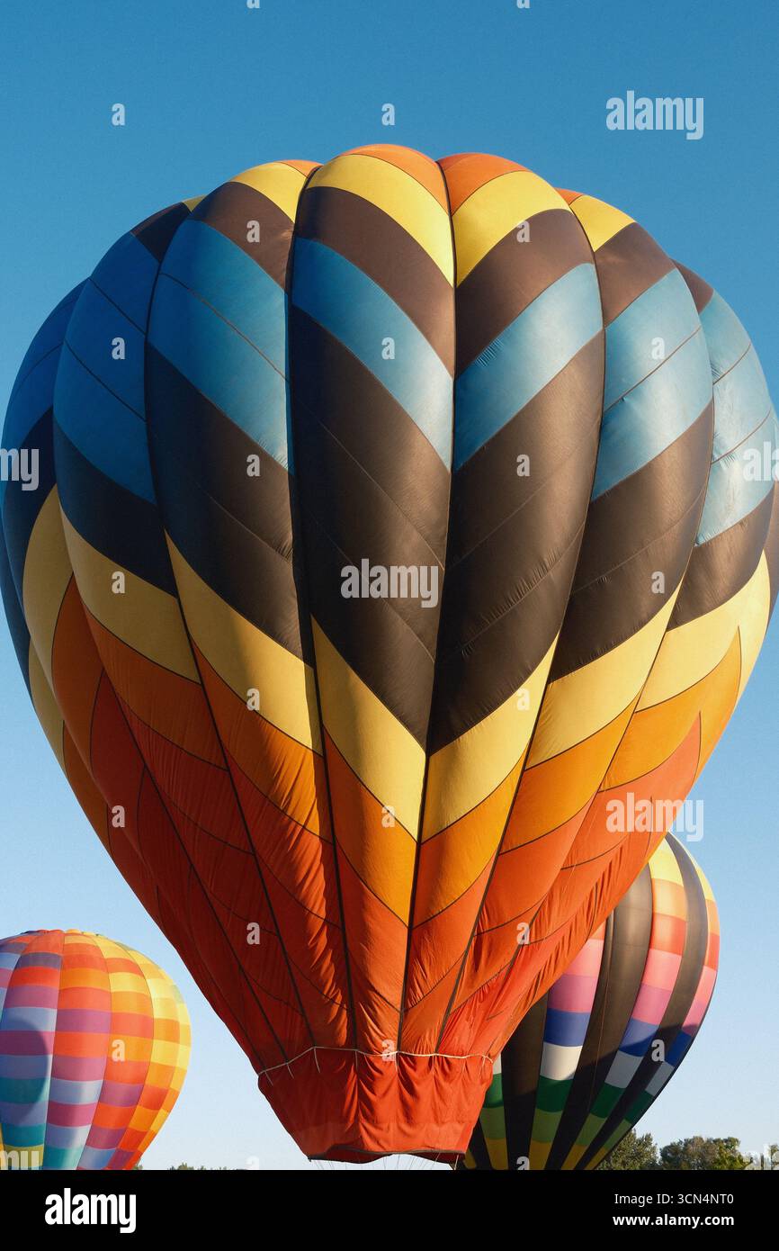 Palloncini colorati ad aria calda contro un cielo blu vibrante Foto Stock