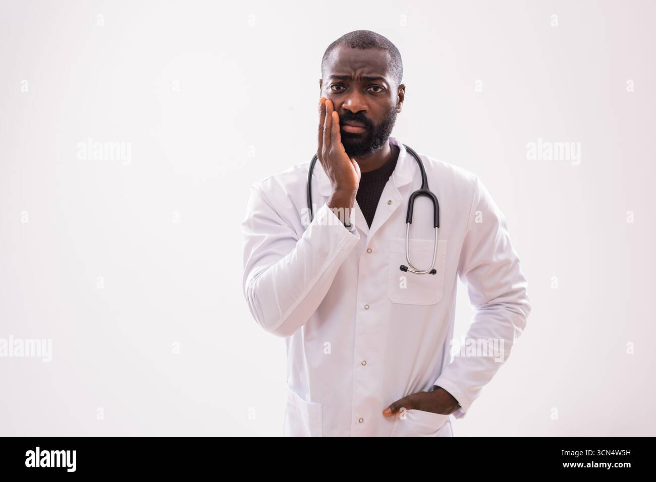 Maschio afroamericano paramedico e medico esperto, sentendo la pressione e lo stress emotivo della sua esigente occupazione. Foto Stock