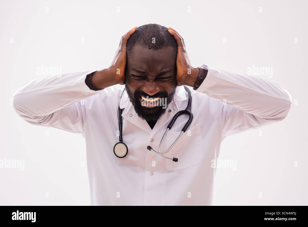 Ritratto di un paramedico ansioso uomo nero che sta affrontando stress e stanchezza. Studio girato su sfondo grigio. Foto Stock