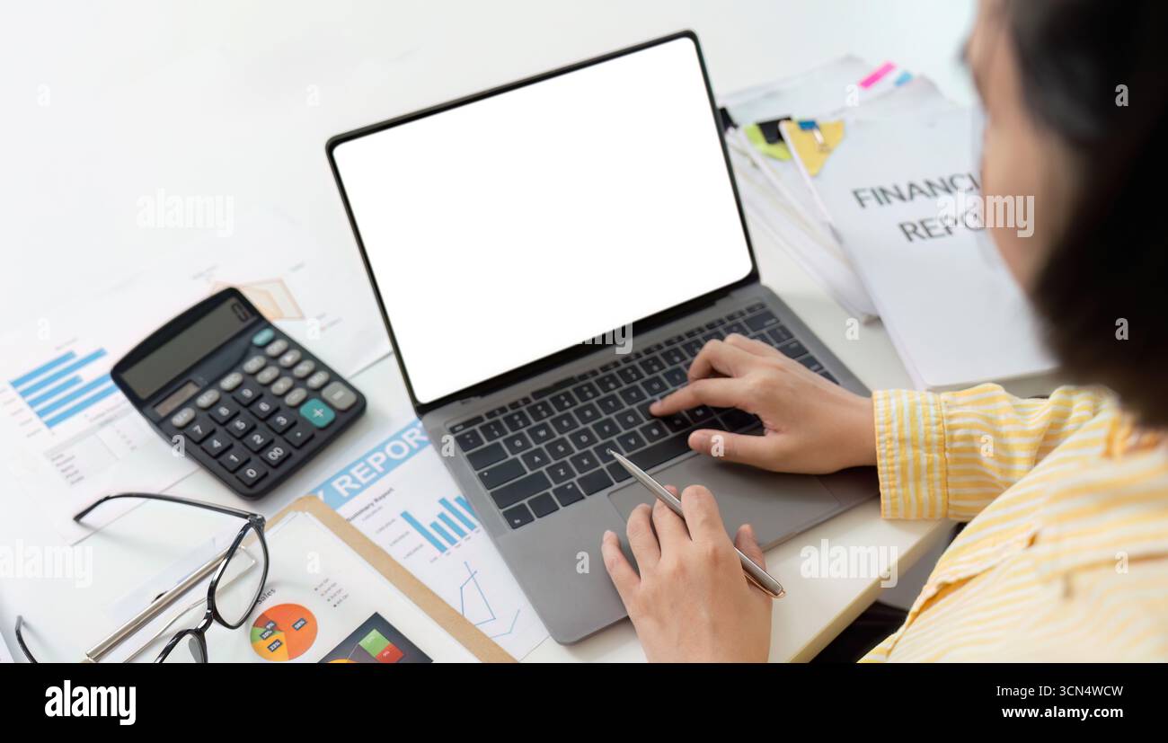 Rendicontazione finanziaria. Contabile che scrive sul laptop con documenti finanziari e calcolatrice. Foto Stock
