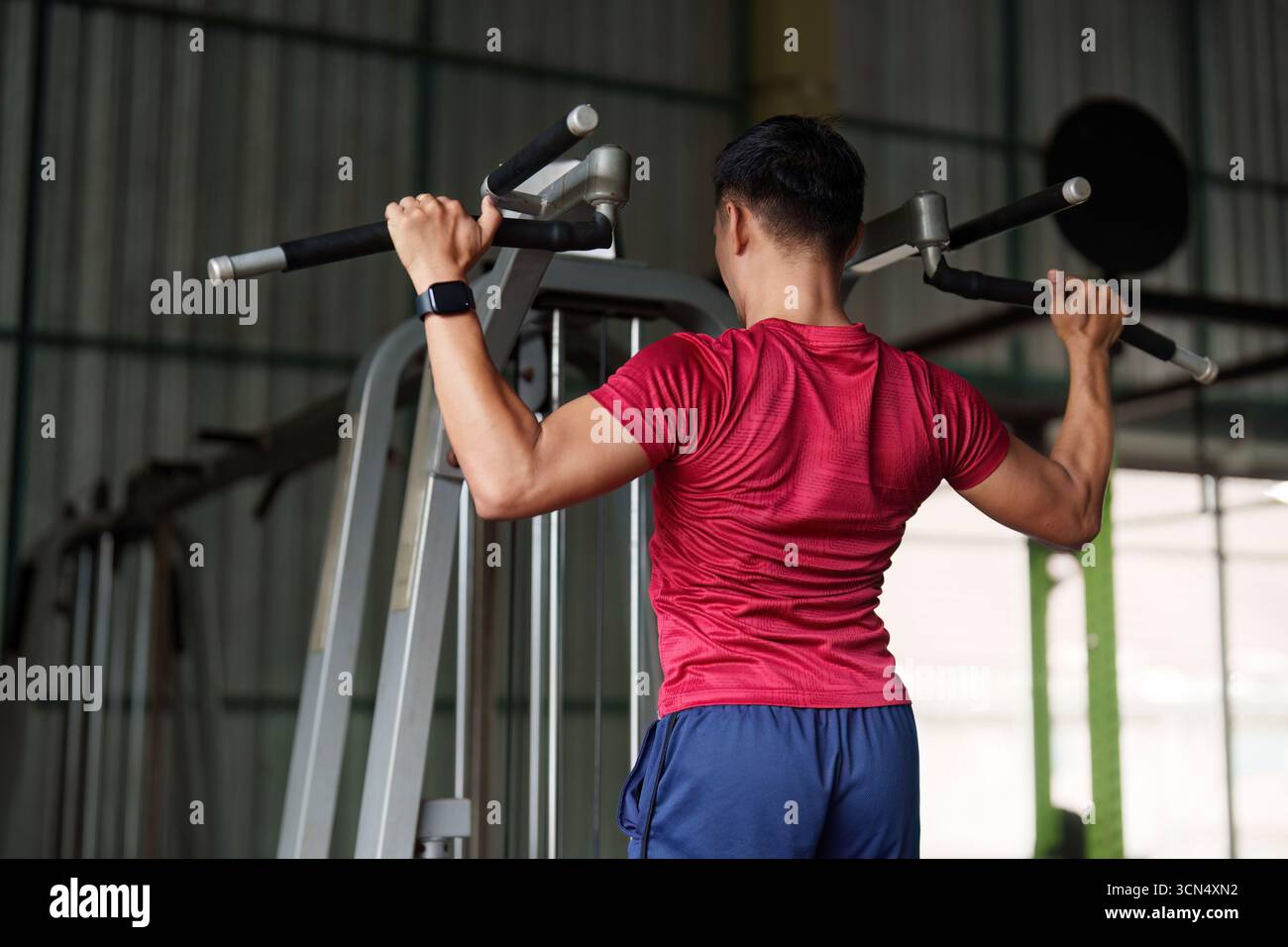 Allenamento di forza. Giovane che fa i pull-up in palestra. Foto Stock