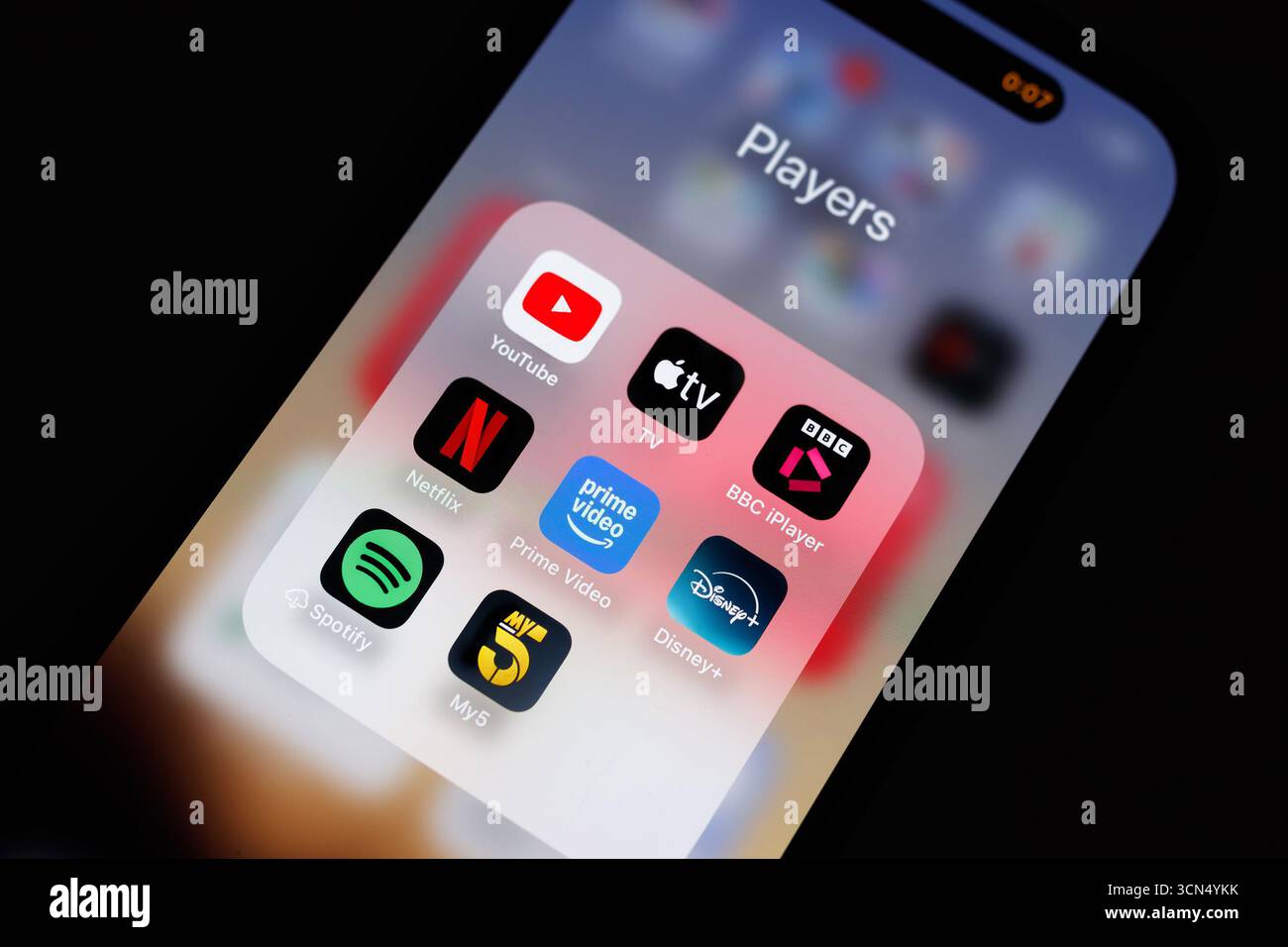 primo piano dello schermo iphone smartphone con una cartella di applicazioni multimediali e di streaming più diffuse: YouTube, Netflix e Disney+ prime video BBC iplayer e Apple TV Foto Stock