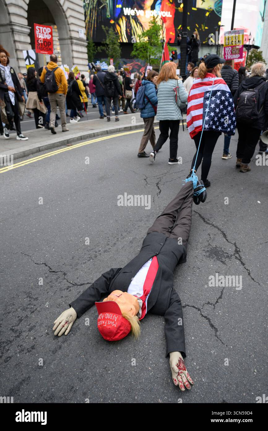 Un marchesino che trascina un'effigie del presidente Trump, partecipa alla manifestazione "Trump Not Welcome”, una protesta nazionale contro quella del presidente americano Trump Foto Stock