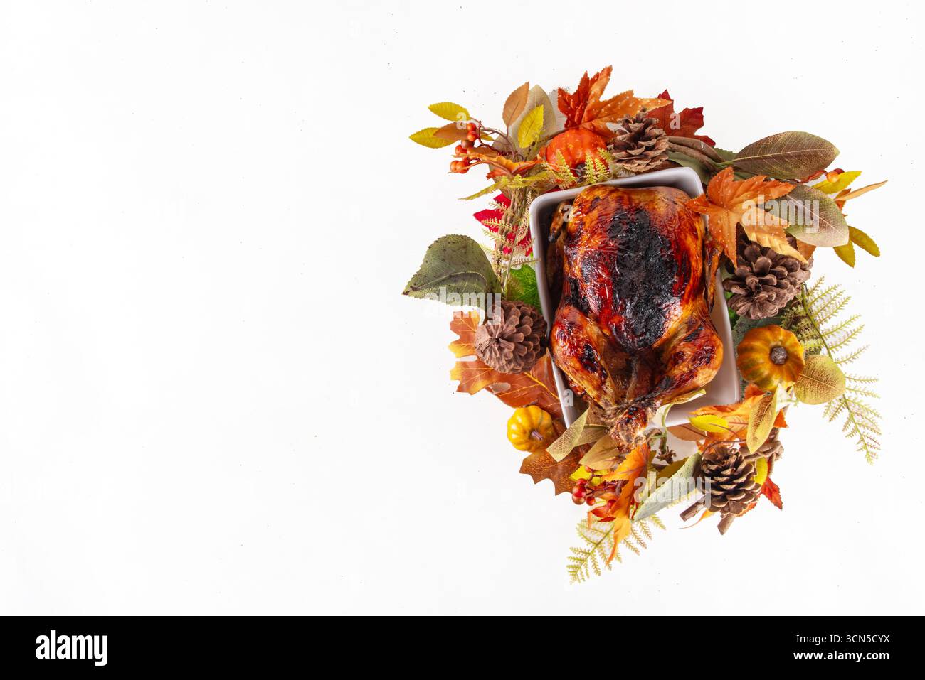 Tradizionale tacchino arrosto festivo del giorno del Ringraziamento con foglie autunnali e decorazioni di zucca su spazio bianco per le copie del tavolo. Cena del giorno del Ringraziamento o menu brunch bac Foto Stock
