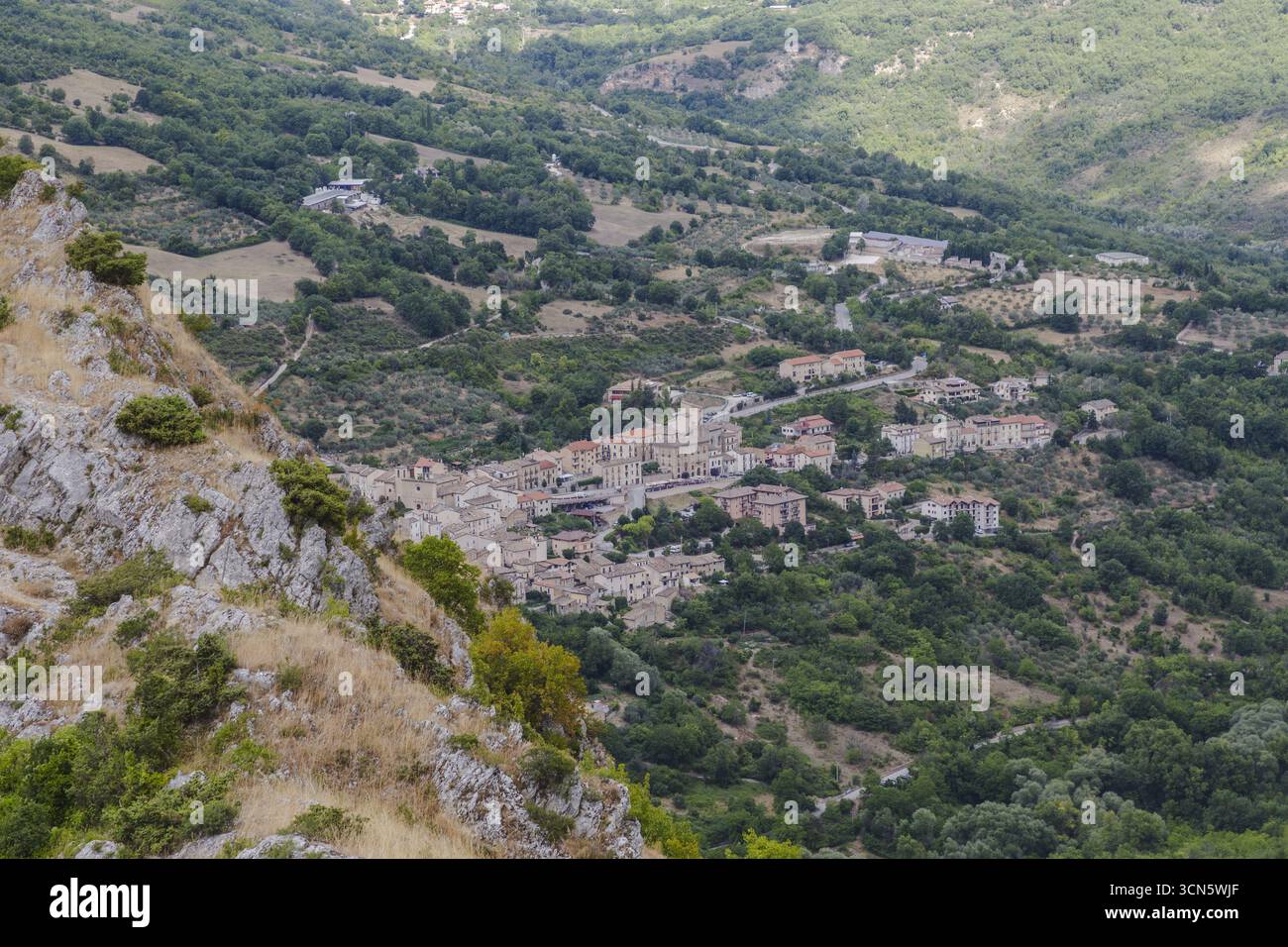 Vista di un pittoresco villaggio annidato tra dolci colline verdi e aspri affioramenti rocciosi, una scena senza tempo di fascino rurale, Castrovalva, Abruzzo, Italia. Foto Stock