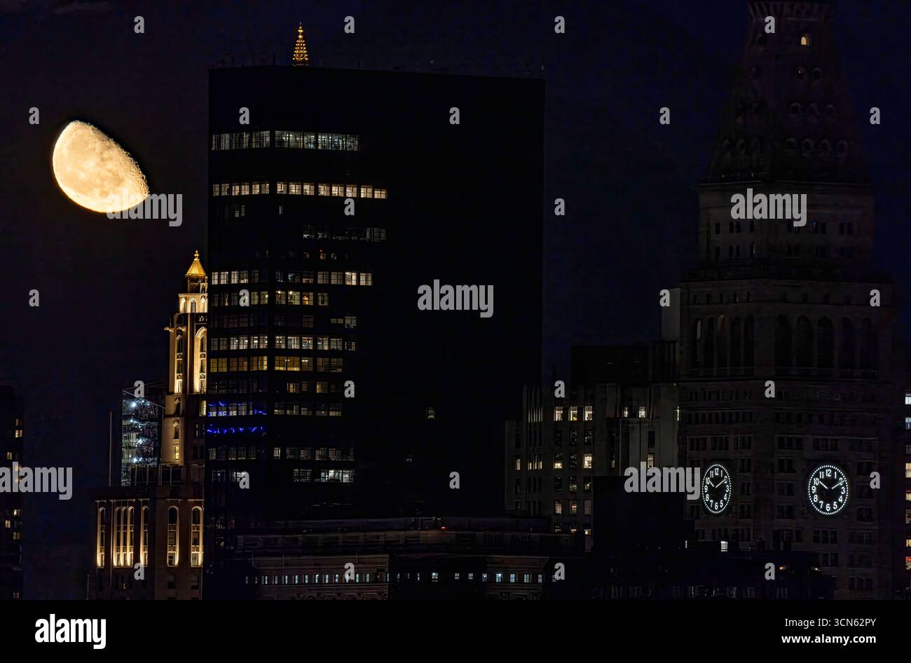 Vista di una luna gibbosa che emette una luce soffusa sulle sagome scure degli edifici, creando un contrasto sorprendente nel cielo notturno di New York, New York, Stati Uniti. Foto Stock