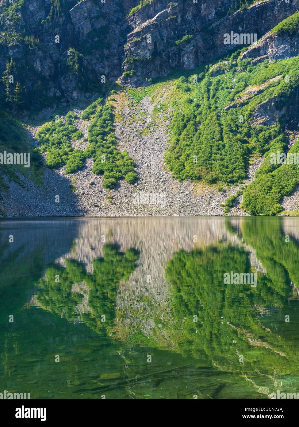 Scivoli dalle montagne alle acque cristalline del Rainy Lake nel North Cascades National Park, Washington Foto Stock