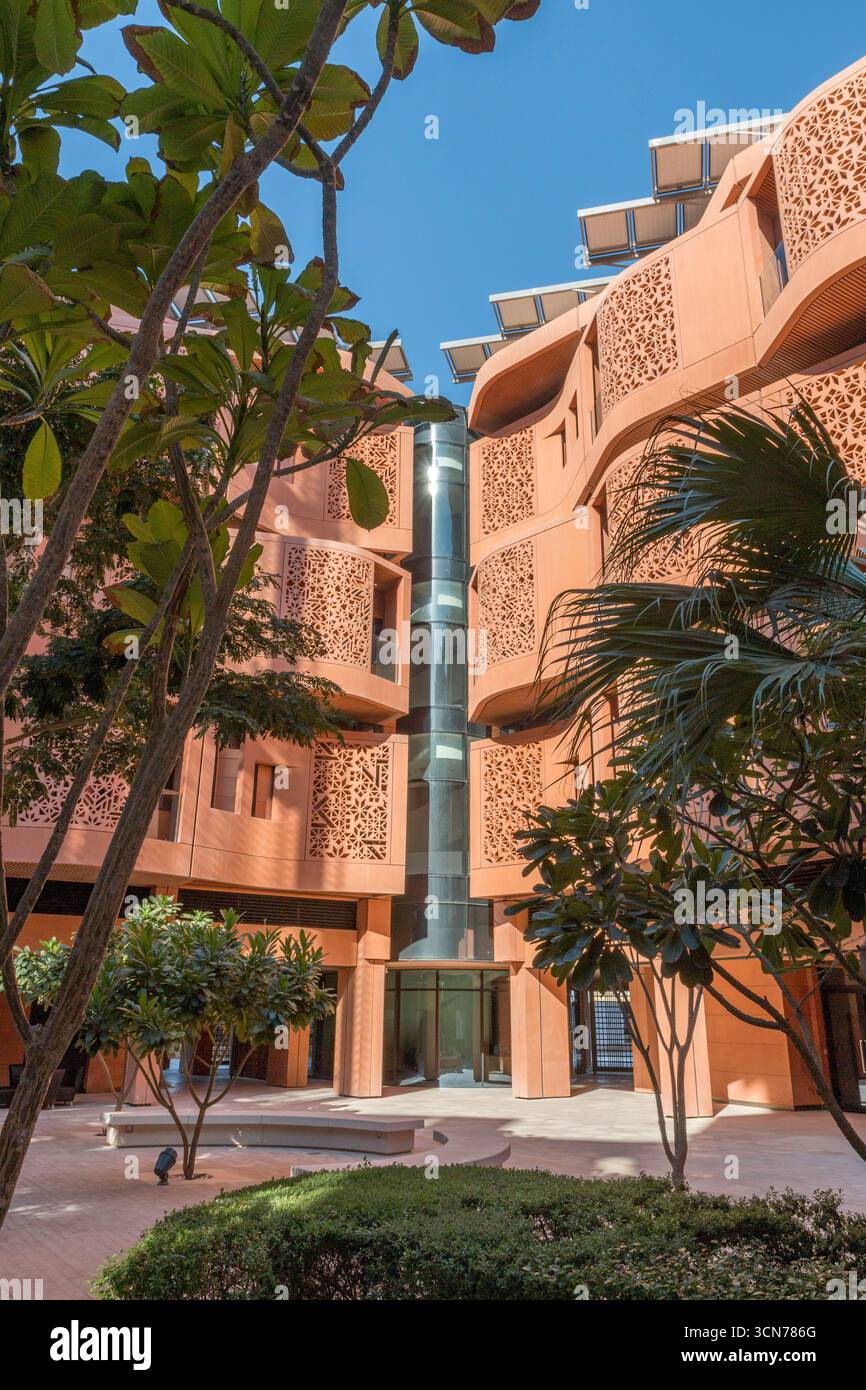 Emirati Arabi Uniti - Abu Dhabi - Masdar City - cortile paesaggistico incorniciato da palme e pareti color miele, un microclima calmo nato dall'ombra e dalla brezza Foto Stock