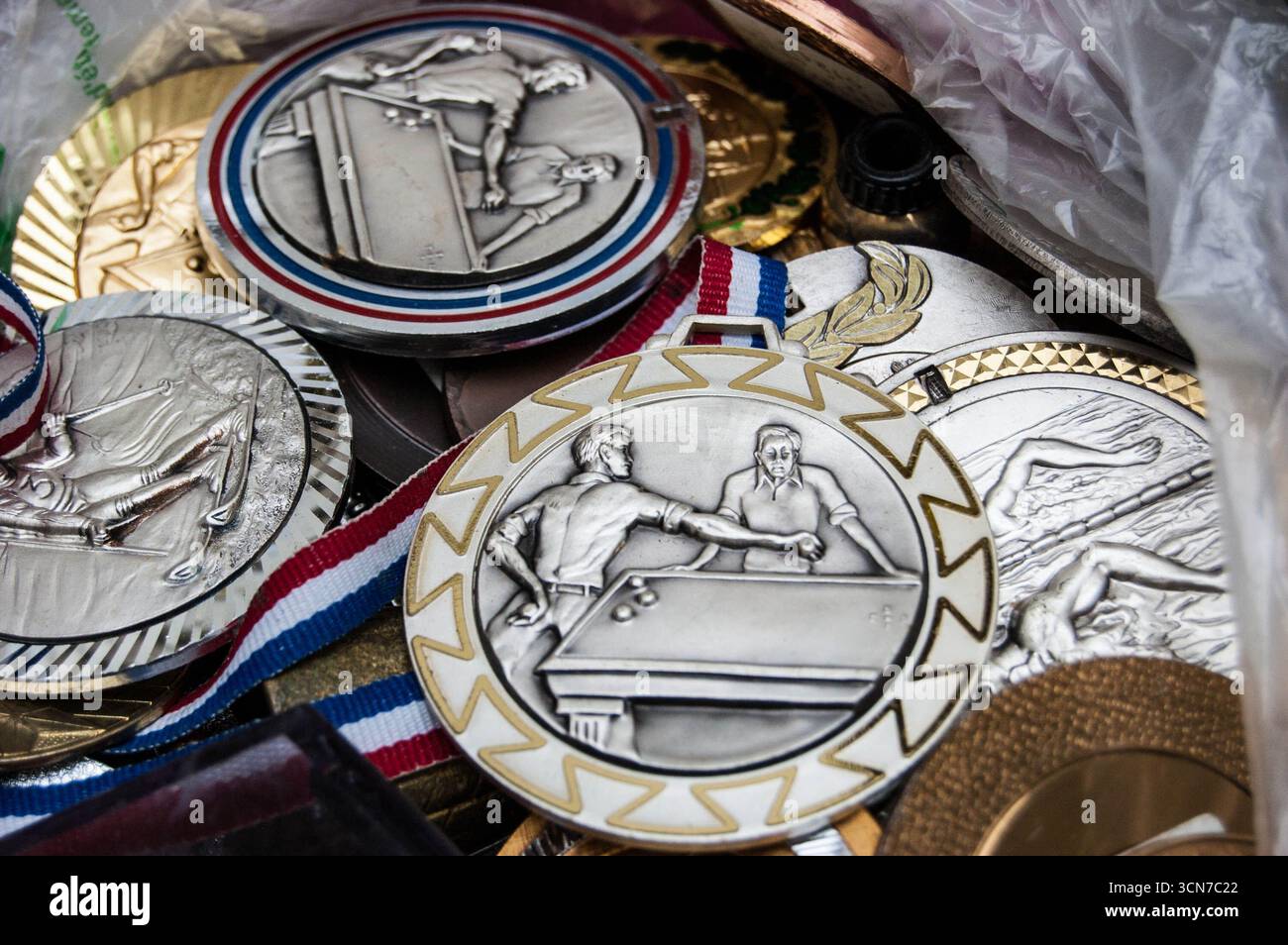 Medaglie sportive vintage uniche in vendita al mercato delle pulci di Parigi, Francia. Biliardo, nuoto e medaglie di sci. Foto Stock