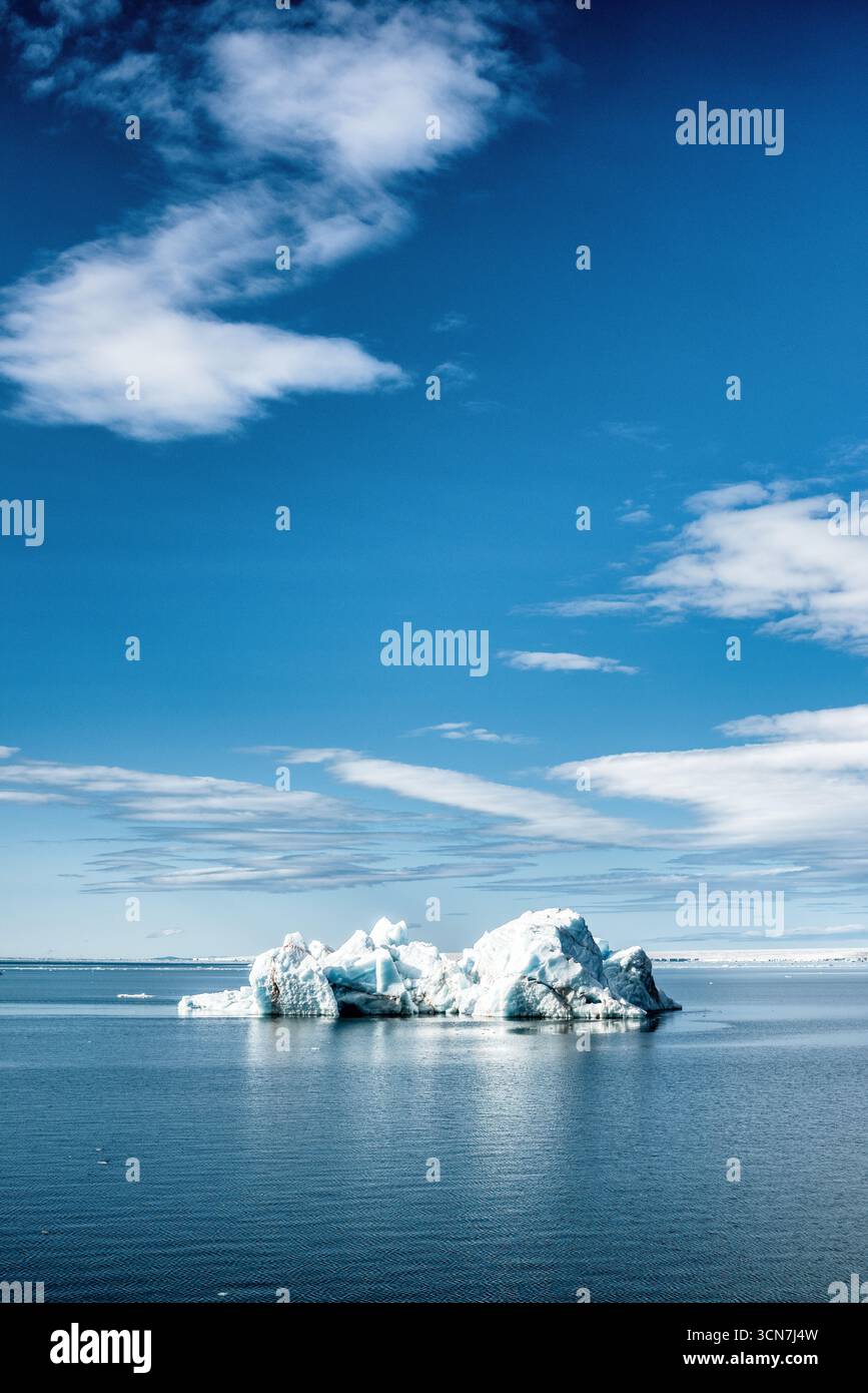 Klerckbukta Nordaustlandet Svalbard Iceberg // NORDEAUSTLANDET, Svalbard — Un grande iceberg galleggia nell'Oceano Artico al largo della costa di Nordaustlandet, Svalbard, un'isola situata nell'arcipelago artico delle Svalbard e Jan Mayen. L'iceberg è una massa di ghiaccio che si è rotto da un ghiacciaio o da una piattaforma di ghiaccio e che galleggia liberamente nel mare. Nordaustlandet è la seconda isola più grande delle Svalbard ed è caratterizzata dalle sue vaste calotte glaciali e dai ghiacciai. L'arcipelago delle Svalbard si trova nell'Oceano Artico, a metà strada tra la Norvegia continentale e il Polo Nord. Foto Stock