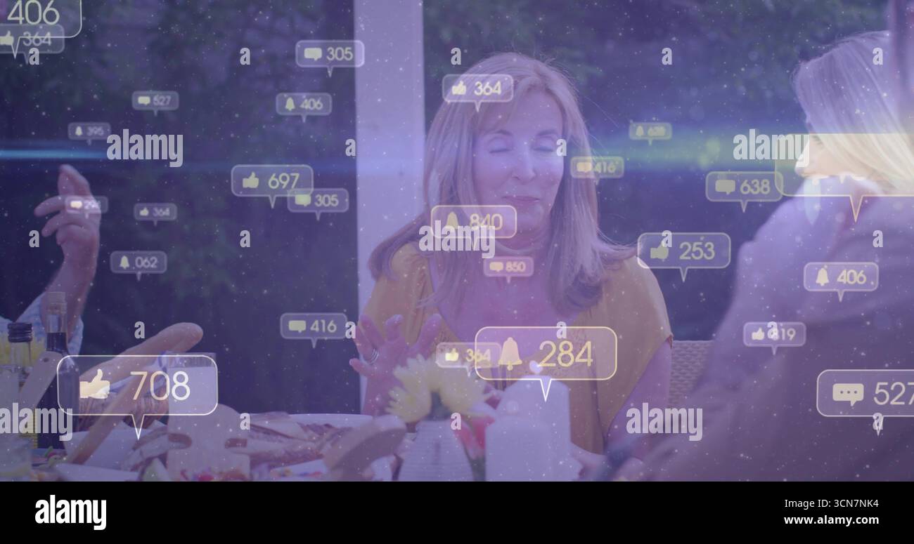 Donna matura che indossa una camicetta di senape che conduce una chiacchierata in famiglia al sole con icone di notifica fluttuanti Foto Stock