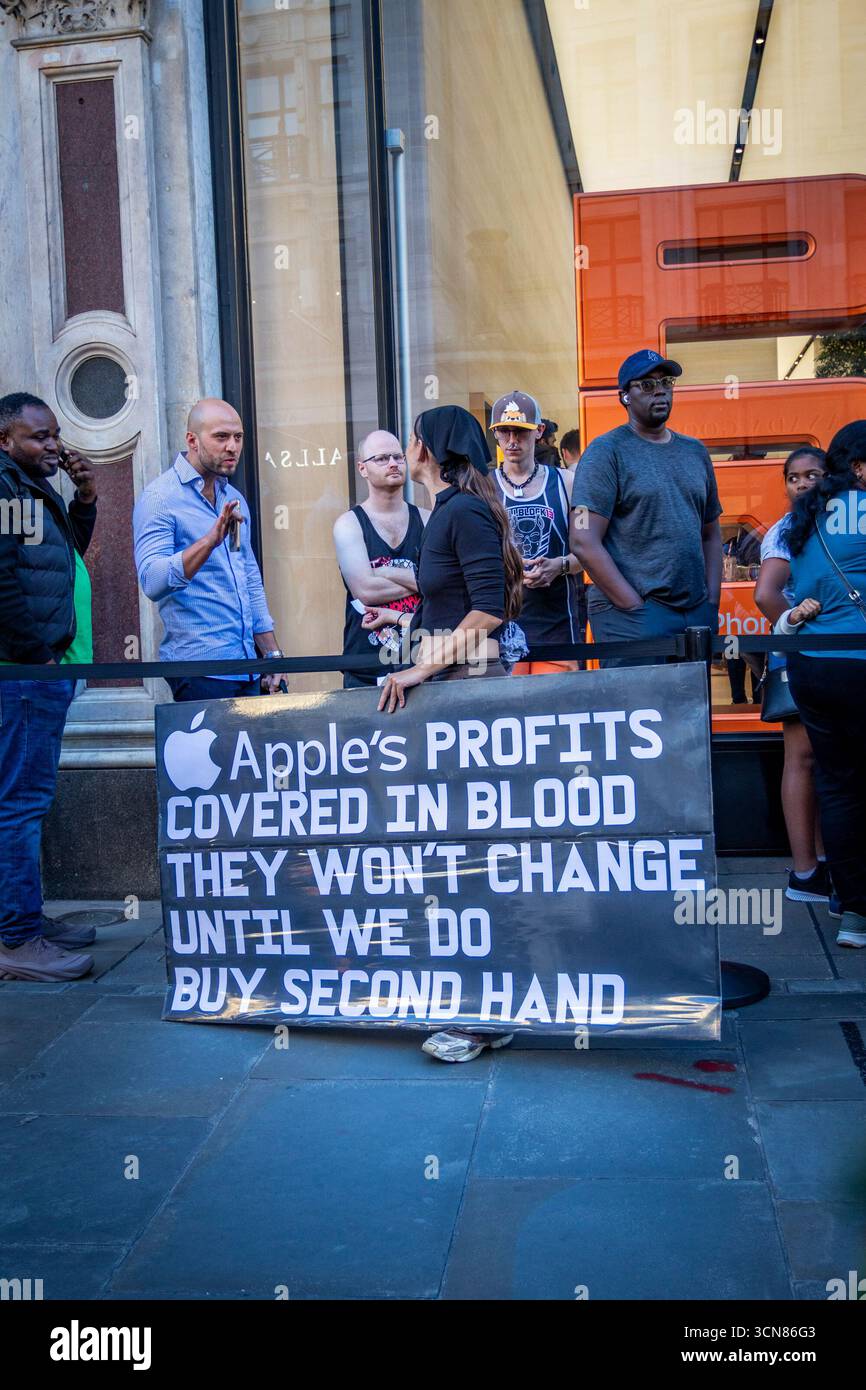 Gli attivisti hanno organizzato una protesta fuori dall'Apple Store in Regent Street, nel centro di Londra, il 17 settembre durante il lancio dell'iPhone 17. I manifestanti hanno tenuto manifesti che dichiaravano “iPhone 17 coperto di sangue”, accusando Apple di trarre profitto dalle miniere di cobalto in Congo legate al lavoro minorile e alle violazioni dei diritti umani. Le code dei clienti che tentavano di entrare nell'Apple Store di Regent Street sono state incontrate con canti, cartelloni e spettatori che si sono riuniti per assistere alla protesta. Foto Stock