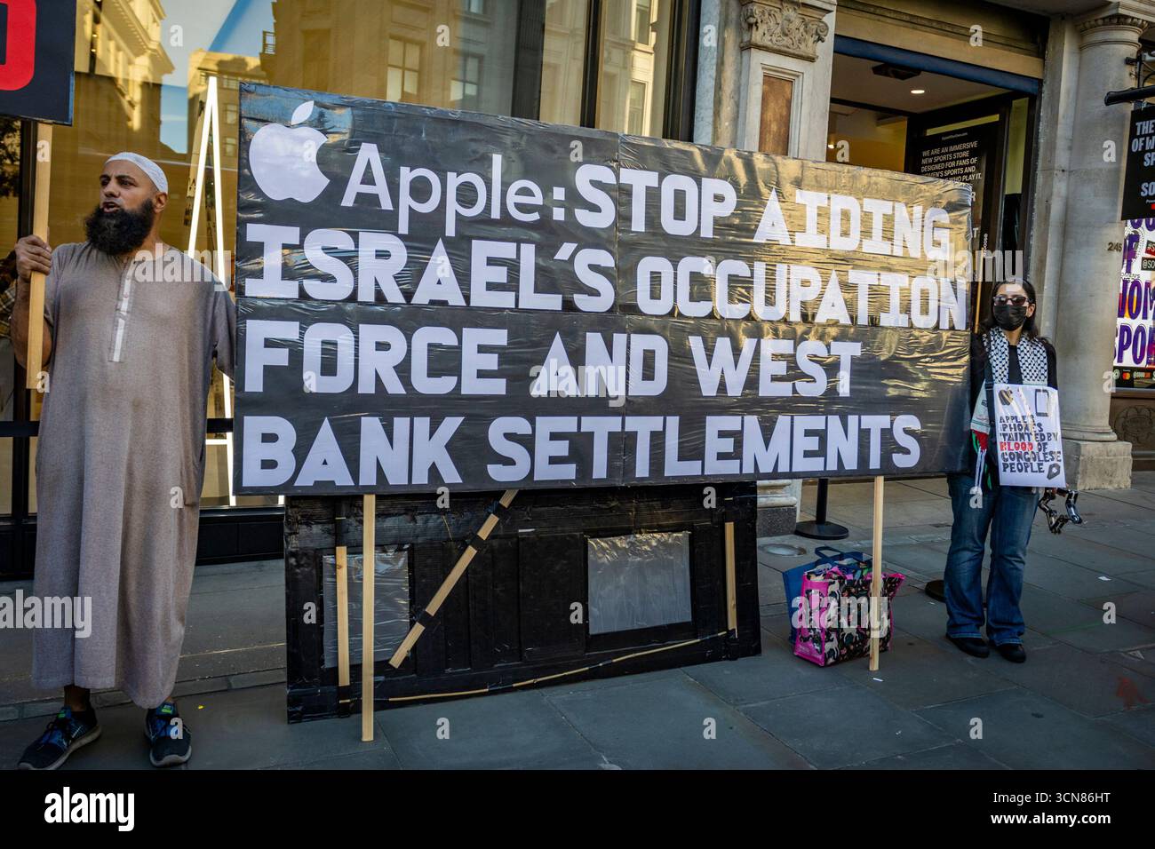 Gli attivisti hanno organizzato una protesta fuori dall'Apple Store in Regent Street, nel centro di Londra, il 17 settembre durante il lancio dell'iPhone 17. I manifestanti hanno tenuto manifesti che dichiaravano “iPhone 17 coperto di sangue”, accusando Apple di trarre profitto dalle miniere di cobalto in Congo legate al lavoro minorile e alle violazioni dei diritti umani. Le code dei clienti che tentavano di entrare nell'Apple Store di Regent Street sono state incontrate con canti, cartelloni e spettatori che si sono riuniti per assistere alla protesta. Foto Stock