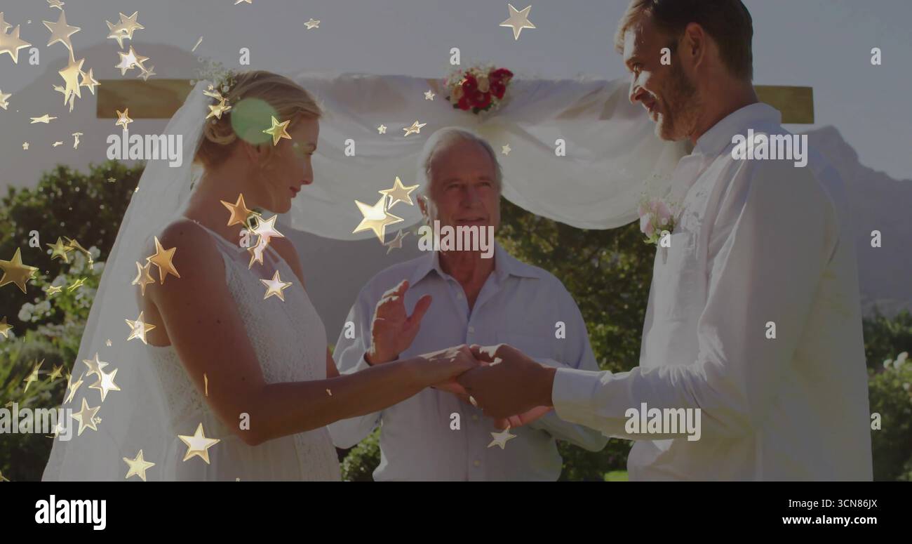 Scambiare le fedi nuziali in piedi all'aperto sotto un arco di legno, con decorazioni floreali Foto Stock