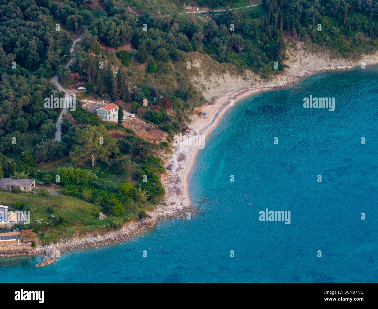 Vista aerea con drone di una villa appartata con spiaggia privata sulla splendida costa turchese di Corfù, Grecia. Una fuga paradisiaca nascosta nel cuore della Foto Stock