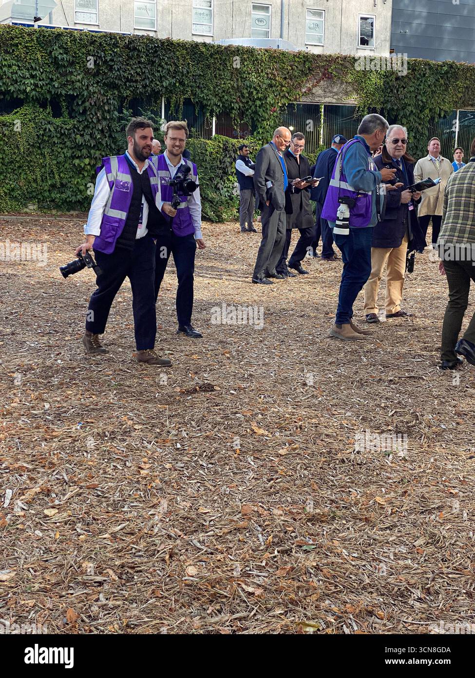 Irish Champions Festival, ippodromo di Leopardstown, Dublino, Irlanda. Maneggiatori, fantini e purosangue nel paddock prima della gara. - Immagine stock catturata con smartphone