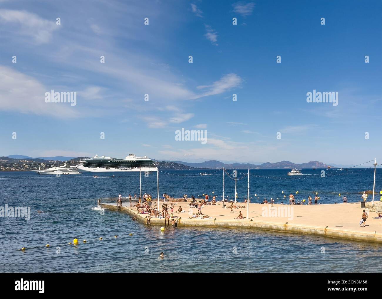 Saint Tropez, Francia - 13 luglio 2024: Scenario del centro. Molo di Plage de la Ponche con più bagnanti e navi, grande e piccolo sulle acque del Golfo u Foto Stock