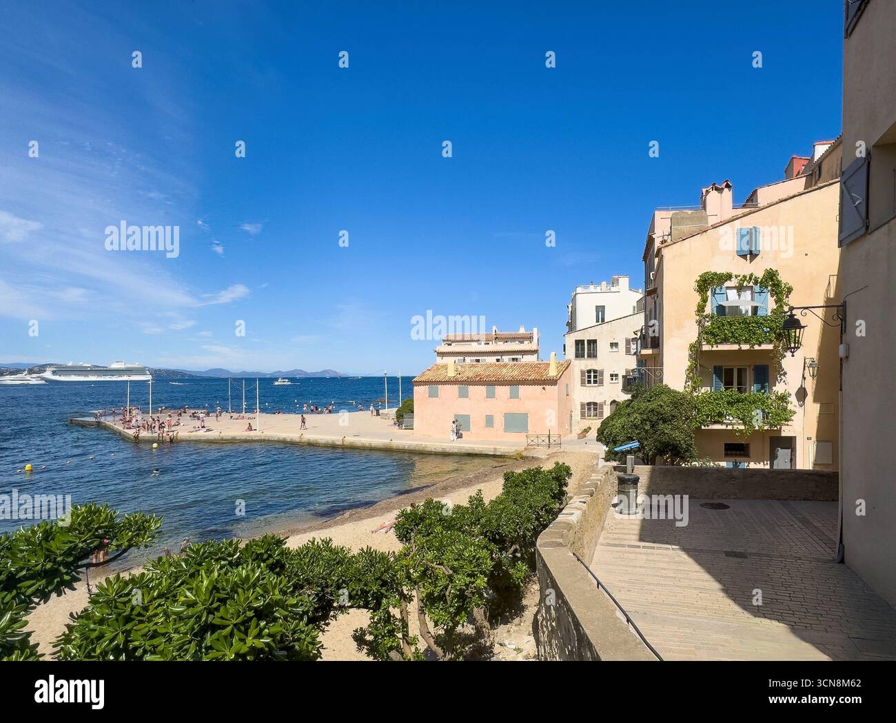 Saint Tropez, Francia - 13 luglio 2024: Scenario del centro. Molo di Plage de la Ponche con gli edifici circostanti per lo più residenziali sotto il cielo blu. S Foto Stock
