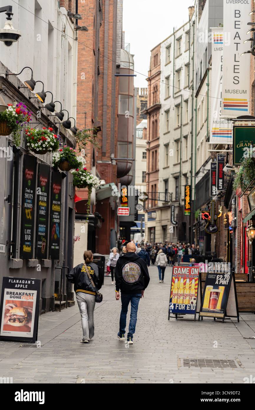 I fan dei Beatles che indossano giacche esplorano Mathew St, Liverpool, Regno Unito Foto Stock